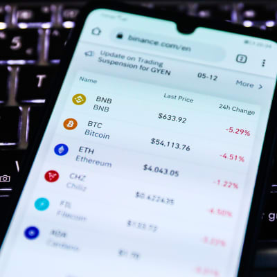 En mobilskärm visar värdet på olika virtuella valutor, bland annat Binance coin och Bitcoin. 