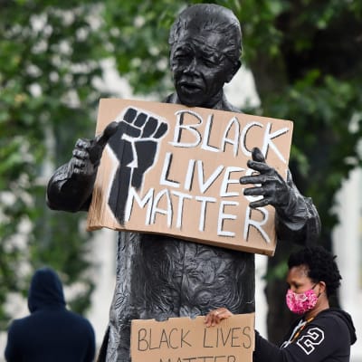 Demonstranter vid Nelson Mandela staty i London under en antirasism protest.