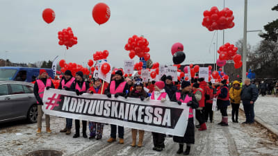 STTK:s ordförande Antti Palola står i första ledet vid ett demonstrationståg. 