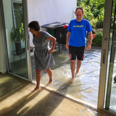 Två Houstonbor inspekterar sitt översvämmade hem.