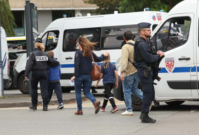 Poliser och barn vid en skola i Frankrike.