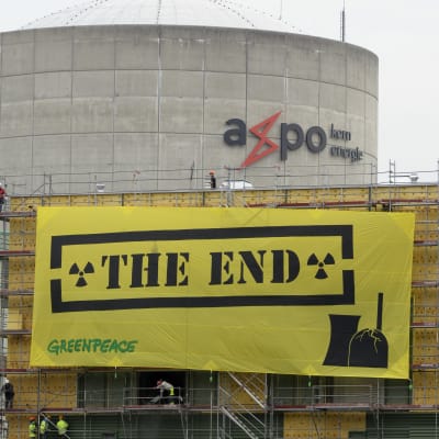Schweiziskt kärkraftverk med Greenpeace banderoll i förgrunden.