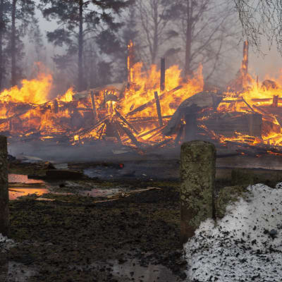 Rautjärven kirkon rauniot tulessa.