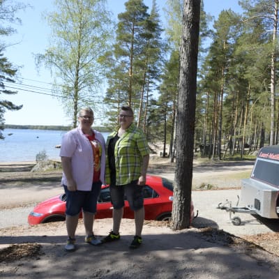 Annukka Masalin ja Taija Kattelus seisovat auton ja asuntovaunun edustalla. Taustalla näkyy meri.