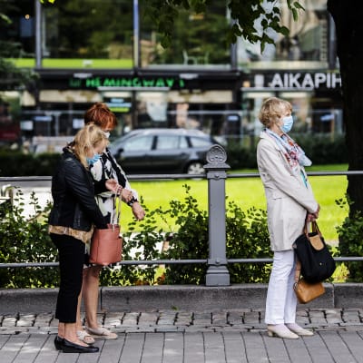 Kvinnor med munskydd köar till en utställning vid Ateneum i Helsingfors.