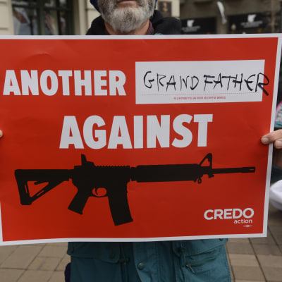 En man håller upp en skylt med texten, En till morfar mot vapen, för att protestera mot liberala vapenlagar i USA.