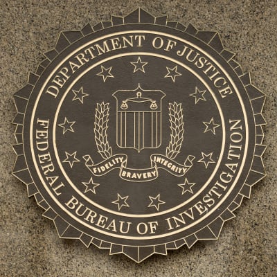 Den amerikanska federala polisen FBI:s vapen mot en grå vägg.