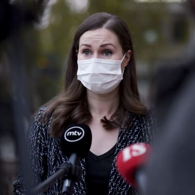 Sanna Marin utanför Ständerhuset 15.10.2020. Hon bär munskydd och intervjuas av journalister.