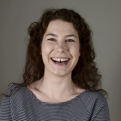Porträtt av De Grönas riksdagsledamot Emma Kari som skrattar.