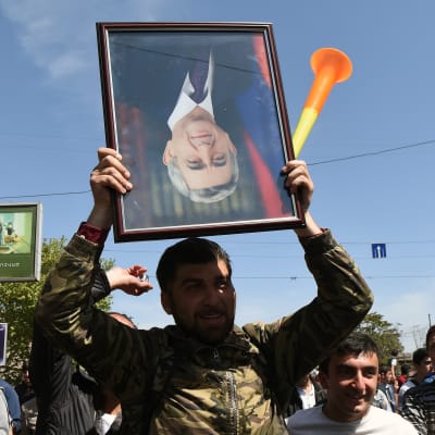 Demonstrant håller ett porträtt av premiärminister Serzj Sargsian upp och ner under en av de många demonstrationerna i huvudstaden Jerevan. 