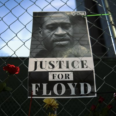 George Floydin kuolemasta syytetyn poliisi Derek Chauvinin oikeudenkäynti alkoi Minneapolisissa tällä viikolla. Mielenosoittajat asettivat kukkia ja ripustivat julisteita aitaan, joka ympäröi oikeustaloa.