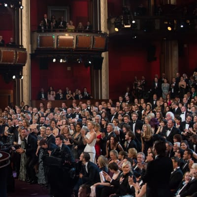 Jennifer Lawrence står på scenen och håller i sin Oscarsstatyett och ser ut över publikhavet som alla står upp och applåderar åt henne.