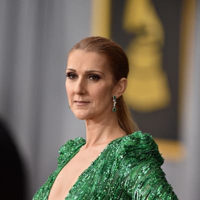 Céline Dion i en grön aftonklänning med djup urringning.