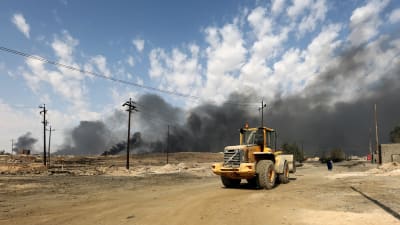 Rök från brinnande oljefält söder om Mosul överskuggar slagfälten kring Iraks näst största stad
