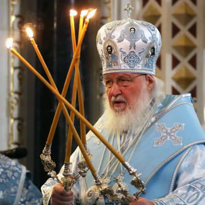 Patriarkka Kirill toimittaa jumalanpalvelusta kynttelikköjä kädessään.