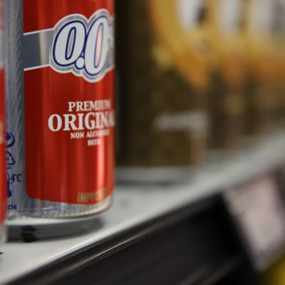 En närbild på burkar med alkoholfritt öl på en butikshylla.
