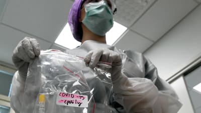 Laboratorieskötare med misstänkt covid-19 provrör