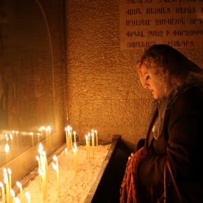 En armenisk kvinna tänder ljus i n kyrka för att hedra minnet av armenierna som dödades i det Osmanska riket mellan år 1915 och år 1917