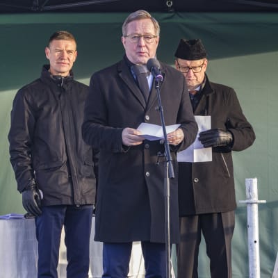 Kolme miestä lavalla