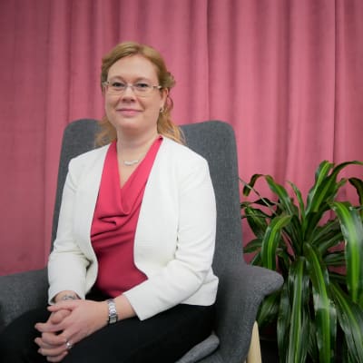 Språkforskaren Jenny Stenberg-Sirén sitter i en stol