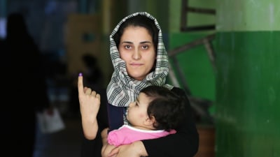 En afghansk kvinna visar upp sitt bläckmarkerade finger efter att ha röstat i Kabul på lördagen. 