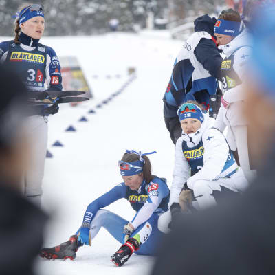 Suomen joukkue naisten viestin jälkeen. Krista Pärmäkoski istuu pettyneenä maassa.