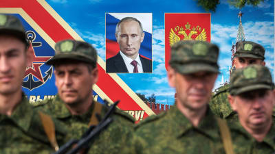 Värvade soldater i Sevastopol med ett porträtt av Vladimir Putin i bakgrunden.