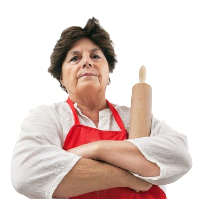 en arg svärmor tittar in i kameran, håller i en degrulle i en a handen.
