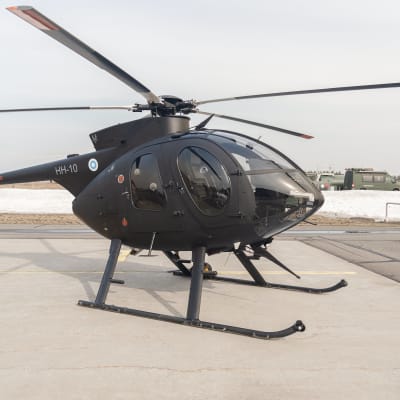 Mustaksi maalattu MD500-kevythelikopteri Utin lentokentällä.