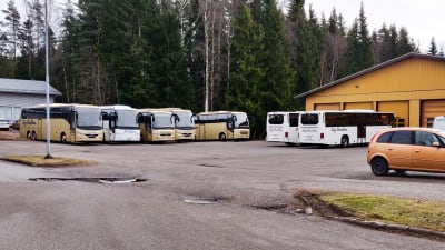 Flera bussar på en parkeringsplats.
