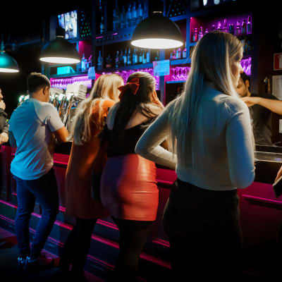 Människor köar vid bardisken i nattklubben Maxine.