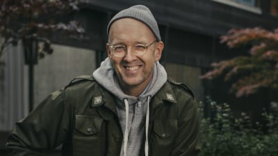 Författaren Johan Kling sittande ute på en mur. 2019.