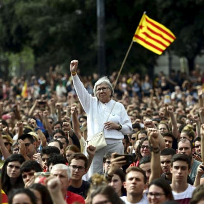 Katalanska demonstranter höjde sina knutna nävar under en demonstration i Barcelona på måndagen mot den spanska polisens agerande. 