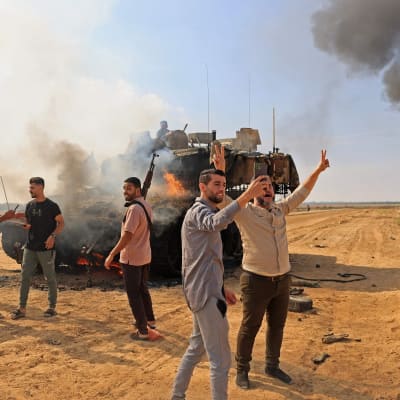 Palestinier tar över israelisk tank vid Gaza-Israel gränsen den 7 oktober 2023.