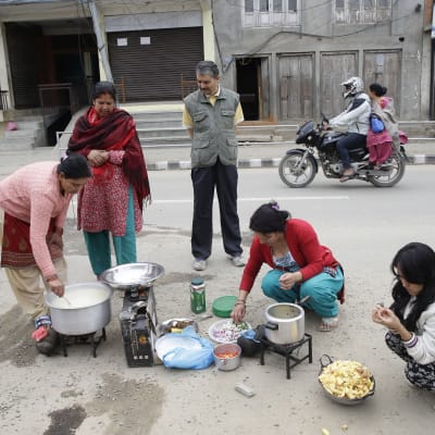 Nepaleser tillreder mat på gatan dagen efter den stora jordbävningen.