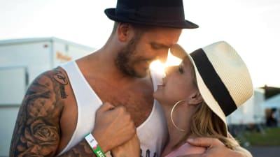 Anneli Magnusson och fästmannen Mikko omfamnar varandra i motljus.