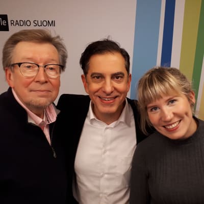 Olli Ahvenlahti, André Chaker ja Anna Keränen seisovat Radio Suomen tunnuksen edessä