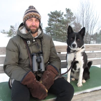 Man och hund sitter på bänk