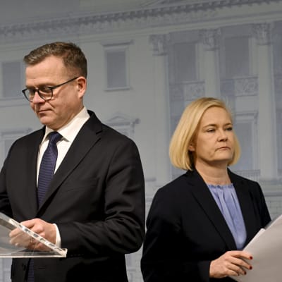 Statsminister Petteri Orpo (Saml) och inrikesminister Mari Rantanen (Sannf) på en presskonferens med papper händerna.