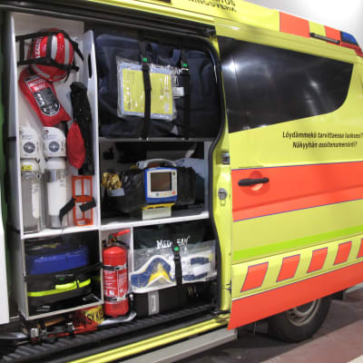 Ambulansens utrustning syns genom bilens öppna dörr.