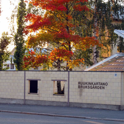 Ruukinkartanon nimikyltti, taustalla syksyisiä punertavia lehtipuita.
