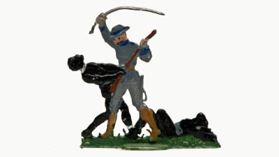 En tennfigur föreställer en vit man som höjer ett svärd ovanför en mörkhyad man. I gräset bredvid ligger en till mörkhyad person.