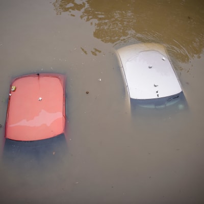 Kaksi autoa upoksissa veden alla.