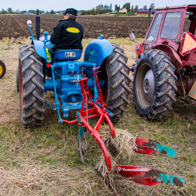 En traktor med en plog påhängd