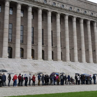 Många köade i duggregnet till riksdagshuset.