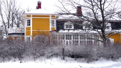 Villa Snäcksund, gulmålad trävilla, i vinterskrud