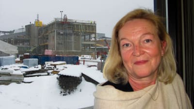 Susanne Dahlqvist med byggandet av Konstfabriken i bakgrunden, det mesta är täckt av snö.