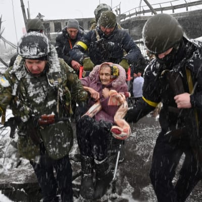 Pelastushenkilökunta kantaa vanhaa naista evakuoidessaan Irpiniläisiä.