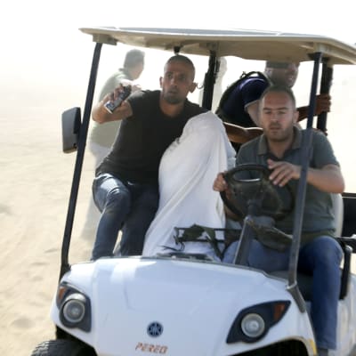 Palestinier transporterar en fångad israelisk civil från Kibbutz Kfar Azza till Gaza på lördagen 7 oktober 2023.