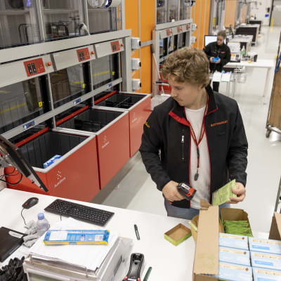  Verkkokaupan keräilijä Valtteri Peltonen lukee varastolaatikoihin siirrettävien tuotteiden viivakoodeja.